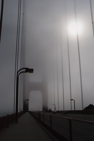 Golden Gate Bridge in thick fog.
Golden Gate Bridge in ocean fog, daytime. The sun can hardly get...