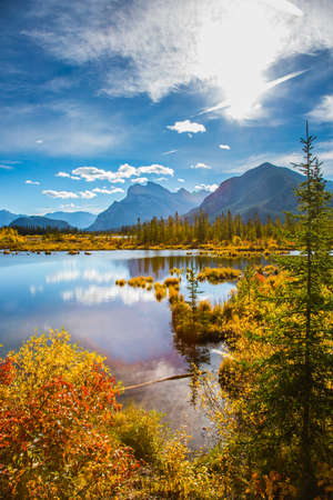 Lake Vermillon among the yellow fall foliage of birches and aspens. Grandiose landscape in the Rocky Mountains of Canada. Travel to autumn. The concept of ecological and photo tourismの写真素材
