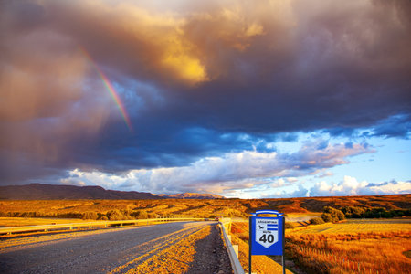 Argentinean prairie and the famous dirt road Ruta 40. Gigantic scenic thundercloud permeated by...