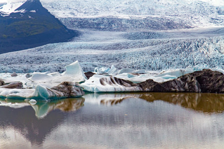 Blocks of ice are reflected in smooth water. Jokulsarlon glacial lagoon. The imposing scenic lagoon...