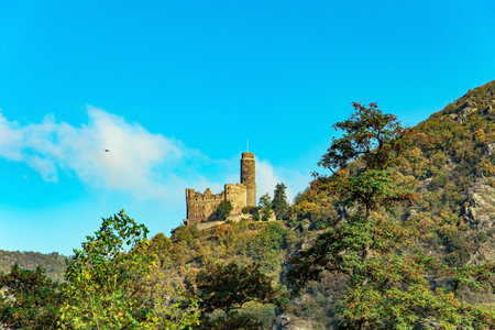 Medieval romantic castles and ruins. Warm autumn in Germany. Beautiful wooded slopes of the coastal hills of the river Rhine. The magnificent and scenic Castle Mouse.のeditorial素材