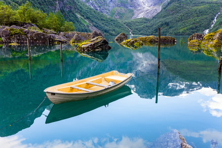Gorgeous mountainous Norway. The mountain lake Bondhuswatnet. Picturesque small boat is moored not...