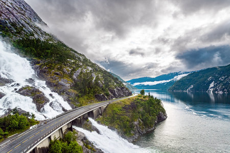 Langfossen cascade waterfall on the Vaule river. Passes through the highway. Summer cold and rainy day. Western Norway. The photo was taken with a drone.の写真素材