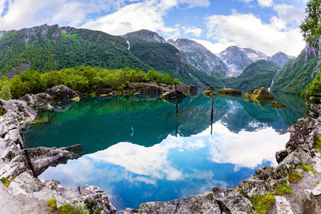 Picturesque mountain lake Bondhuswatnet. The smooth surface of the clear lake water reflects the mountains. Gorgeous mountainous Norway. Evening twilight.の写真素材