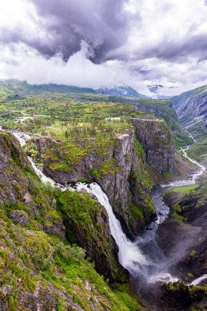Voringsfossen is one of the most famous Norwegian cascading waterfalls. The waterfall falls into a narrow deep picturesque gorge. Rainy cold July in Norwayの写真素材