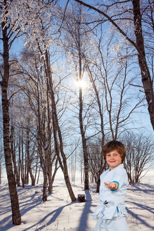 Handsome boy training for judo. New Years is soon. Frosty snowy sunny day in the winter forest. The northern winter sun is low above the horizonの写真素材