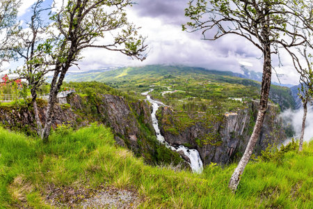 Rainy cold July in Norway. Voringsfossen is grandiose waterfall on the Hardangerfjord. The waterfall falls into a narrow deep picturesque gorge.の写真素材
