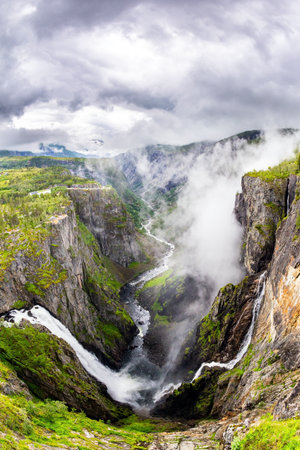 Voringsfossen is one of the most famous Norwegian cascading waterfalls. The waterfall falls into a narrow deep picturesque gorge. Rainy cold July in Norwayの写真素材