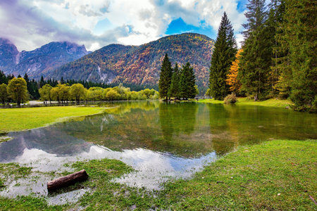 Midday in a mountain valley. Picturesque shallow lake Fuzine of glacial origin. The lake shores are flooded. Wonderful warm autumn dayの写真素材