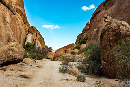Africa. Spitzkoppe is picturesque rock massif in Namibia. Magnificent stone red-orange remains of Spitzkoppe. Dirt road passes between stones. Adventurous journey to an exotic country.の写真素材