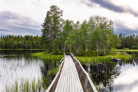 Gorgeous quiet lake and a small island in the middle. There is a wooden bridge to the island. Northern Europe. Summer trip to Norway.の写真素材