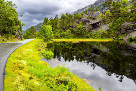 Quiet small lake next to the road. The picturesque road in Norway. Summer trip to the north of Europe. Summer cold and rainy day. Western Norway.の写真素材