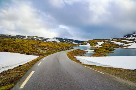 Great "Snow Road". Huge cold snowfields and sharp stone placers. Cold July in Northern Europe. Journey to the fabulous northern country of Norway.の写真素材