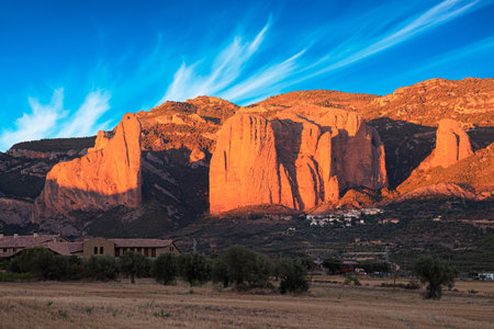 The magnificent Mallos de Riglos cliffs is a conglomerate of rock formations. Gorgeous red sunset. The magical nature of northern Spain, Aragon. Part of the foothills of the Pyreneesの写真素材