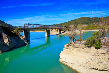 Picturesque cliffs, still water and bridge. Indian summer in northern Spain. The La Penia Reservoir collects the waters of the Gallego River. Wonderful autumn day.の写真素材