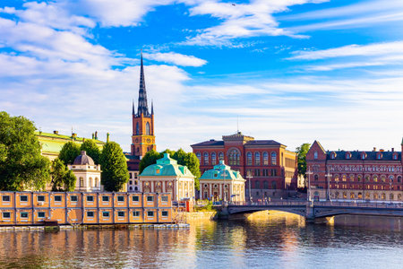 Golden sunset light illuminates the ancient buildings of the city. Hot summer day. Wonderful excursion to the Stockholm. Stockholm is the picturesque northern capital of Sweden.の写真素材