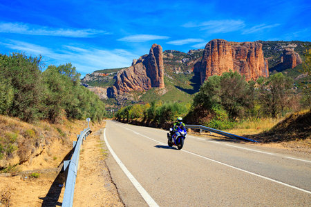 Motorcyclist speeding down the highway. Part of the foothills of the Pyrenees. The Mallets of Riglos. Romantic trip to Spain. Aragon.の写真素材