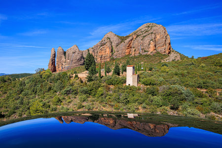 The rocks are beautifully reflected in the shiny surface of the car. Aguero village at the foot of the dangerous Mallos cliffs. The magical nature of Spain. Province of Huesca, Aragon.の写真素材