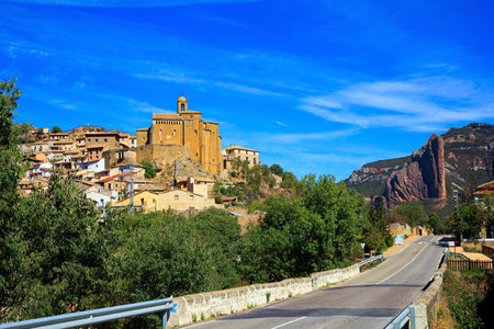 Asphalt highway passes through the rocks. The Mallets of Riglos. Hoya de Huesca, Aragon. Part of the foothills of the Pyrenees. Hot sunny afternoon. Romantic trip to Spain.の写真素材