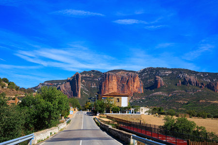 The picturesque Mallets of Riglos. Asphalt highway passes through the rocks. Hoya de Huesca, Aragon. Part of the foothills of the Pyrenees. Hot sunny afternoon. Romantic trip to Spain.の写真素材