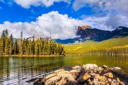 Pyramid Lake. Mount Pyramid is covered by cumulus clouds. The lake is covered with light water ripples. Cold sunny day in the Rocky Mountains of Canada.の写真素材