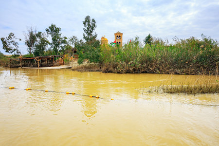 Yellow water of the wide Jordan River. Place of the Baptism of Jesus Christ in Israel - Qasr el Yahud. The Jordan River - state border between Israel and Jordan.の写真素材
