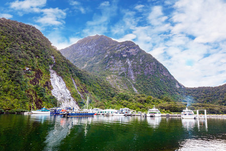 Port of tourist and pleasure ship and boats of the Milford Sound fjord. Fiordland park. The magical nature of the southern hemisphere. South Island, New Zealand.の写真素材