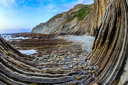 Incredibly bizarre coastal cliffs. Flysch - unique landscape of underwater rocks exposed at low tide. Playa Zumaya. The Basque Country - Itsurun. Coast of the Bay of Biscay, Atlantic.の写真素材
