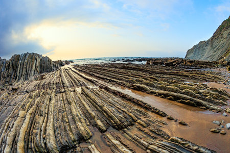 Coast of the Bay of Biscay, Atlantic. Incredibly bizarre coastal cliffs. Flysch - unique landscape of underwater rocks exposed at low tide. Playa Zumaya. The Basque Country - Itsurun.の写真素材