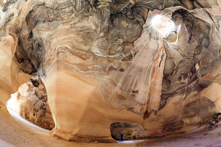 The famous underground national park Beit Guvrin, Israel. Bell Caves - quarries of the 7th century AD. Ancient caves for the extraction of building materials. A sunbeam in the ceiling picturesquely illuminates the vaults of the cave. Sunny warm day for a のeditorial素材