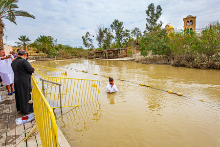 QASR EL YAHUD, ISRAEL - MARCH 2, 2020: Young woman enters the water. The site of the baptism of Jesus Christ. The rite of Baptism in a historical place on the Jordan River.のeditorial素材