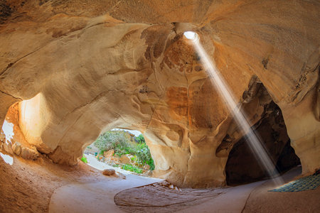 Bell caves - quarries of the 7th century AD. The famous underground national park Beit Guvrin, Israel. Sunbeam in the ceiling illuminates the vaults of the cave. Sunny dayの写真素材