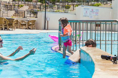 Parents and children swim, dive and laugh together. Family vacation in a hotel on the Greek island of Cyprus. Great swimming pool with clear water. Happy familyの写真素材