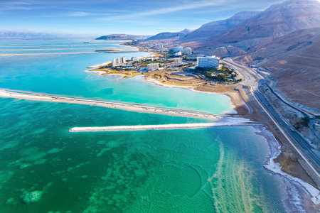 Asphalt highway runs along the seashore. Dead Sea, Israel. Dead Sea photographed from a drone. Evaporated salt was deposited along the shore. Sunsetの写真素材