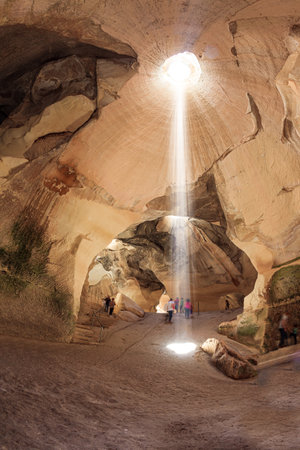 The park Beit Guvrin, Israel. Bell Caves - quarries of the 7th century AD. Sunbeam in the ceiling illuminates the vaults of the cave. The walls of the cave amaze with a variety of rocksの写真素材