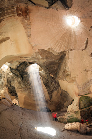 Bell Caves - quarries of the 7th century AD. Sunbeam in the ceiling illuminates the vaults of the cave. The walls of the cave amaze with a variety of rocks. The park Beit Guvrin, Israel.の写真素材