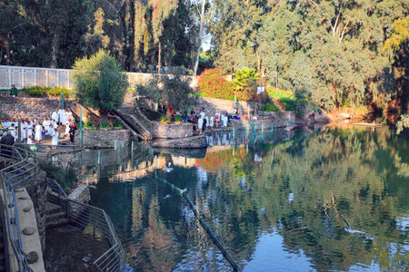 YARDENIT, ISRAEL - JANUARY 21, 2012: Christian pilgrims. Group of believers in white baptismal shirts. The exit point of the Jordan River from Lake Tiberias is Yardenit. Cold sunny January day.のeditorial素材