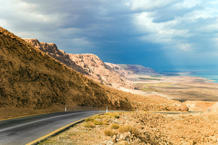 Highway along the seashore. The Judean Desert is one of the most famous deserts in the world. The most salty sea on earth - Dead Sea. Israel, winter cloudy day.の写真素材
