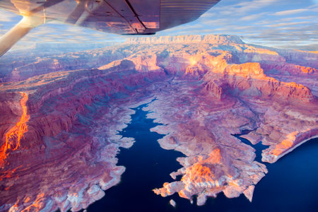 Landscape under the wing of an airplane. U.S. The coast of Lake Powell is cut by narrow canyons. Grandiose huge lake of artificial origin among the picturesque red sandstone cliffs.の素材 [FY310201252405]