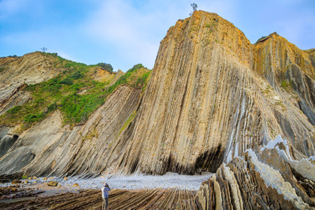 Tourist photographs magnificent landscape. Low tide in the Atlantic. Flysch - unique landscape of underwater rocks exposed at low tide. The Basque Country - Itsurun. Playa Zumaya.の写真素材