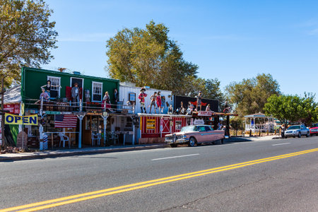 ROUTE 66, ARIZONA, USA - OCTOBER 8, 2009: "Mother of the Roads". Funny souvenir shop. Wall of the house with graffiti. Rusty old car bodyのeditorial素材