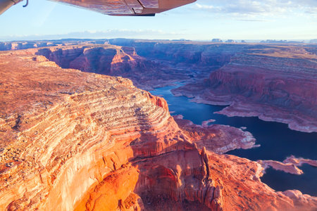 Landscape under the wing of an airplane. Lake Powell is a reservoir on the Colorado River. USA. States of Utah and Arizona. Huge lake of among the red sandstone cliffs.の写真素材