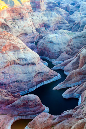 Landscape under the wing of an airplane. The coast of Lake Powell is cut by narrow canyons.  U.S. Grandiose huge lake of artificial origin among the picturesque red sandstone cliffs.の写真素材
