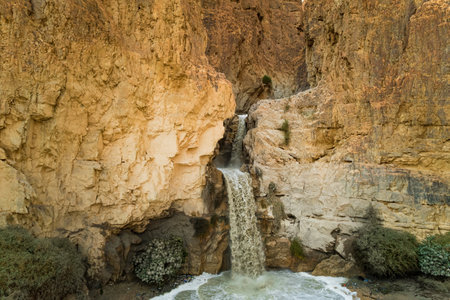 Unexpected powerful waterfall in the Judean Desert around the Dead Sea after heavy winter rains. This is one of the most famous deserts in the world. Shooting from a drone.の写真素材