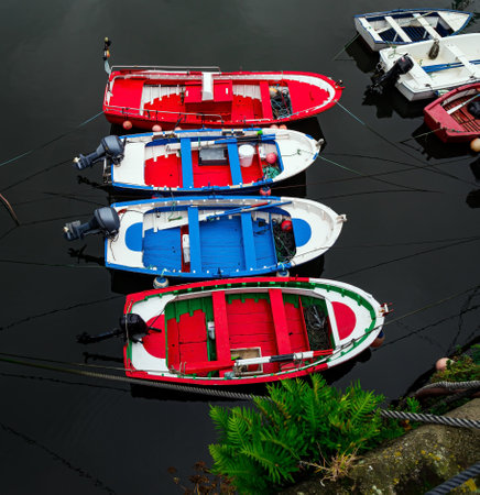 Picturesque colorful fishing boats are moored in the port. Luarca, Atlantic coast, Asturias. Picturesque fishing port in the bay and moored pleasure yachts.  Romantic trip to Spain.の写真素材