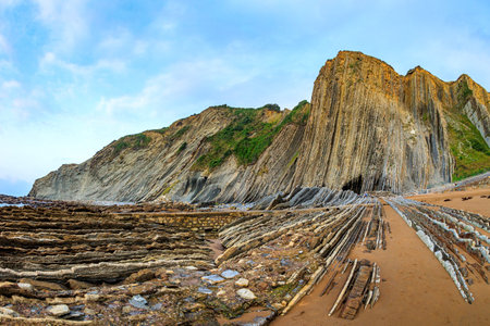 Low tide in the Atlantic. Flysch - unique landscape of underwater rocks exposed at low tide. Incredibly bizarre coastal cliffs. Playa Zumaya. The Basque Country - Itsurun.の写真素材