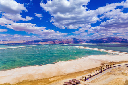 Unusually beautiful landscape. Magnificent Dead Sea. The water reflects the bright blue of the sky. Lush cumulus clouds are reflected in the water. Drone footage. Bright March day. Israelの写真素材