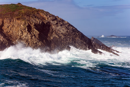 Magnificent Atlantic Ocean. Picturesque fishing port of the city of Luarca in the bay. Huge waves of ocean surf beat against stone breakwaters. Romantic trip to Spain. Asturias.の写真素材