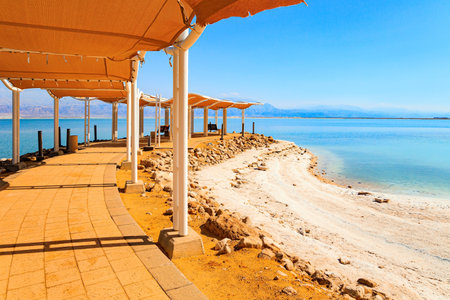 Famous resort in Israel. The Dead Sea is very salty lake in the Middle East. Evaporated salt forms Ñrystals on the water. Special awning on the beach to protect from the sun. Dead Sea Shore.の写真素材