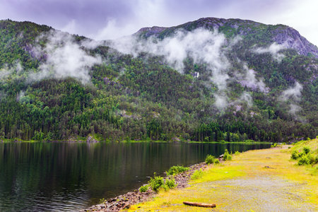 The smooth water of the Acre Fjord. Majestic natural phenomenon. Rainy cold July in Norwayの写真素材
